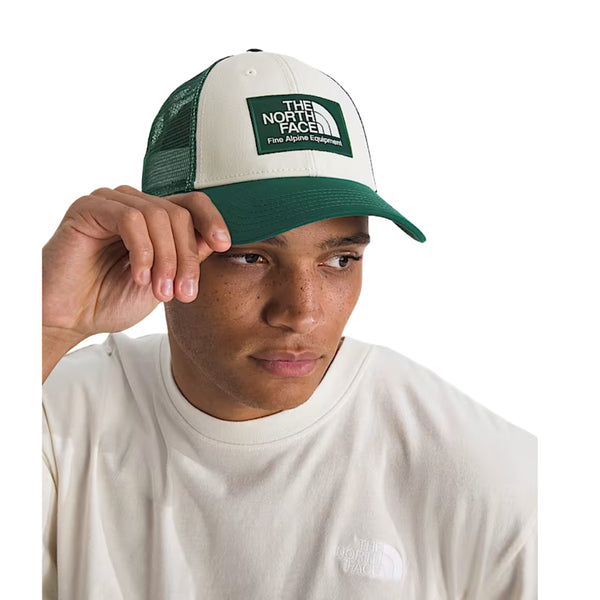The North Face Mudder Trucker Hat with front logo patch, breathable mesh back, and adjustable snapback closure