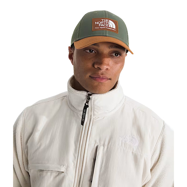 The North Face Mudder Trucker Hat with front logo patch, breathable mesh back, and adjustable snapback closure