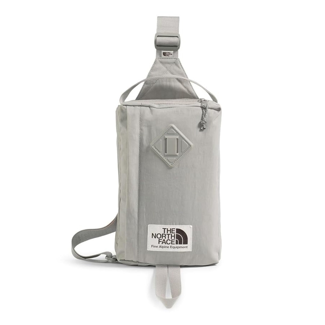 The North Face Berkeley Field Bag in beige with black strap and zippered compartments, styled as a compact crossbody bag.