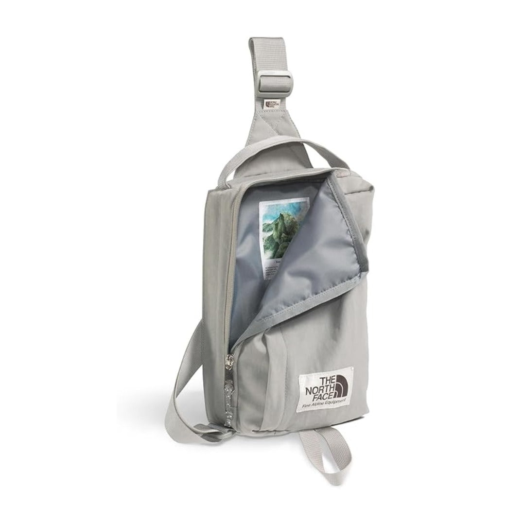 The North Face Berkeley Field Bag in beige with black strap and zippered compartments, styled as a compact crossbody bag.