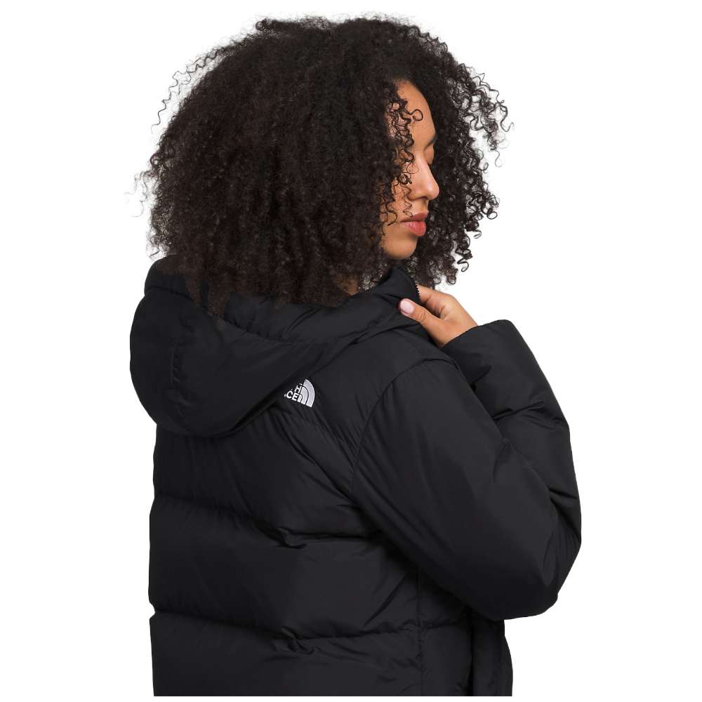 A sleek black north face women's triple c parka worn by women.