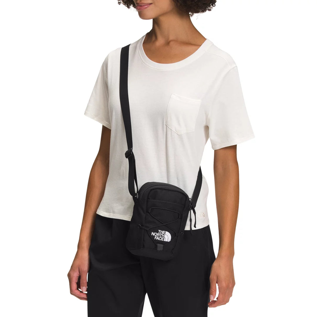 The North Face Jester Crossbody in black, featuring a compact design with multiple compartments and an adjustable strap.