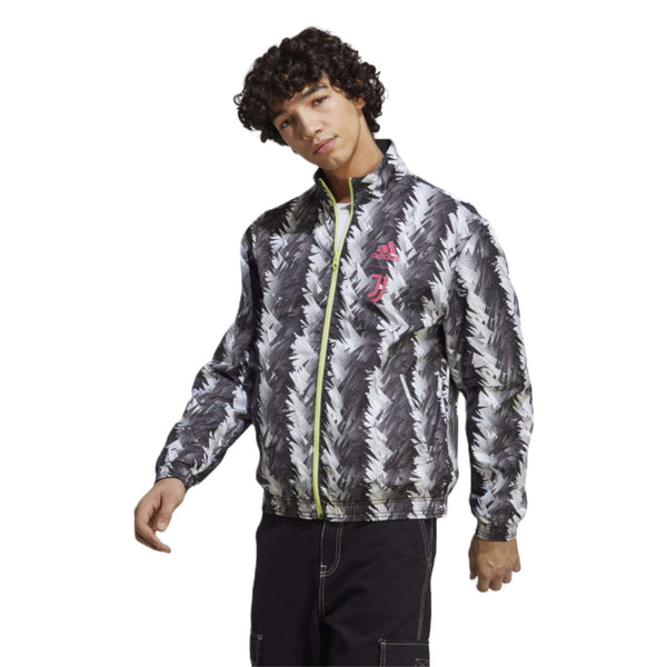A reversible track jacket in black featuring the Adidas and Juventus logos, perfect for showing team support. The front of the jacket has the Adidas logo on the right side of the chest, while the left side features the iconic Juventus crest. The jacket is made of high-quality materials and has a sleek design.
