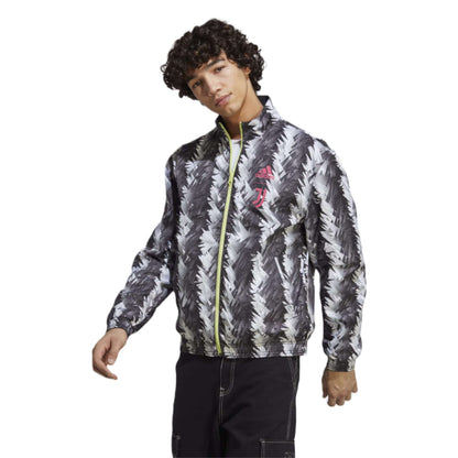 A reversible track jacket in black featuring the Adidas and Juventus logos, perfect for showing team support. The front of the jacket has the Adidas logo on the right side of the chest, while the left side features the iconic Juventus crest. The jacket is made of high-quality materials and has a sleek design.