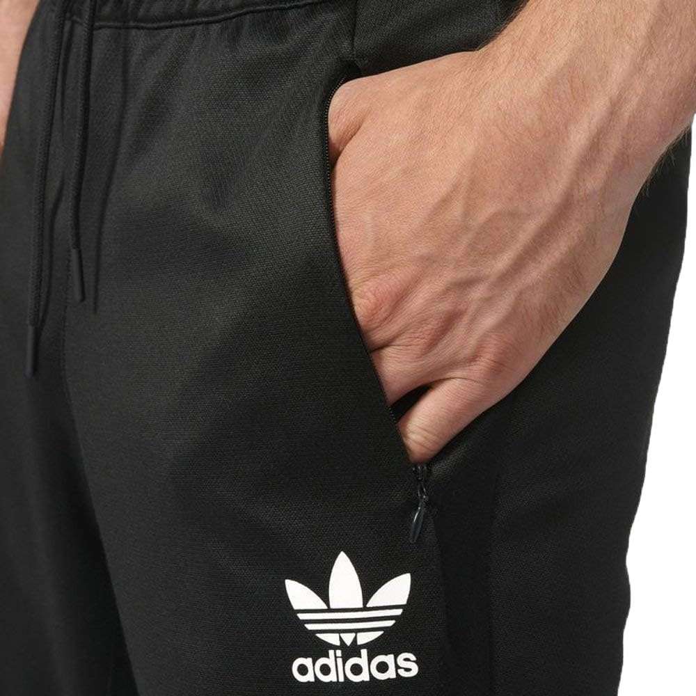 A man wearing adidas Men's Originals BLK/WVN T90 TIRO Track Pants