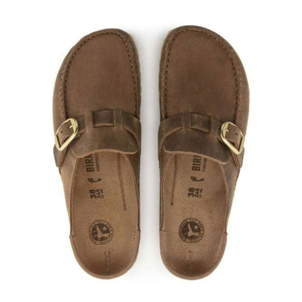 Slip-on clog featuring a structured upper, adjustable buckle strap, contoured cork-latex footbed, and durable outsole for everyday comfort and casual wear