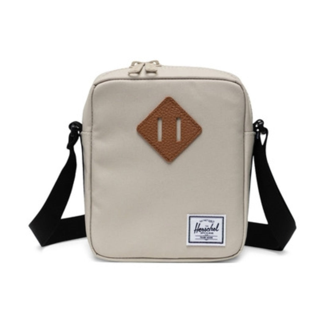 Herschel Heritage crossbody bag with a compact design, front pocket, adjustable strap, and signature diamond detail for everyday use.