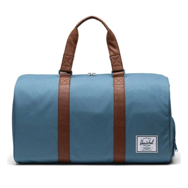 Herschel Novel duffle bag with a large main compartment, side shoe pocket, dual handles, and shoulder strap for travel or gym use.