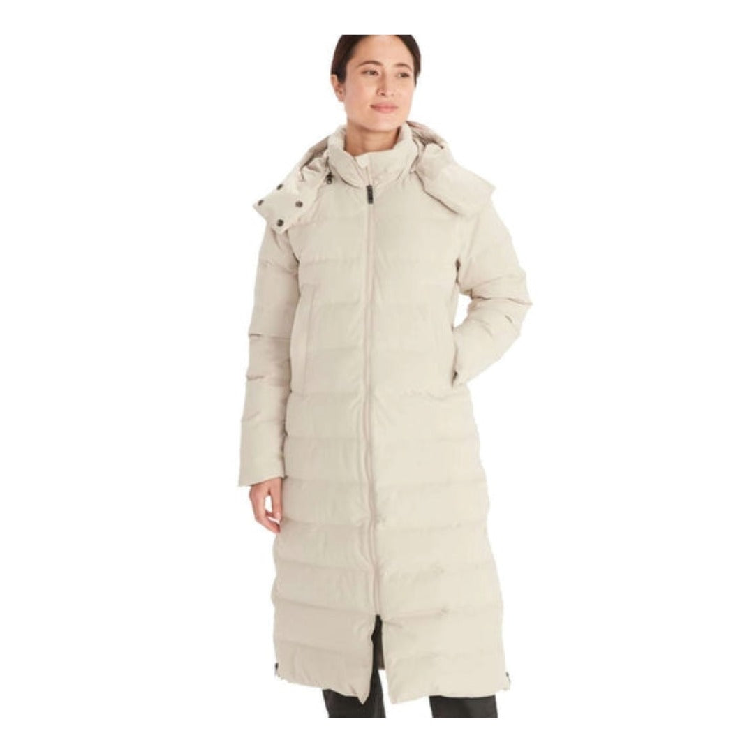 Woman wearing Marmot Prospect long down coat with hood, featuring a full-length insulated design, waterproof fabric, and sleek winter styling for cold-weather protection
