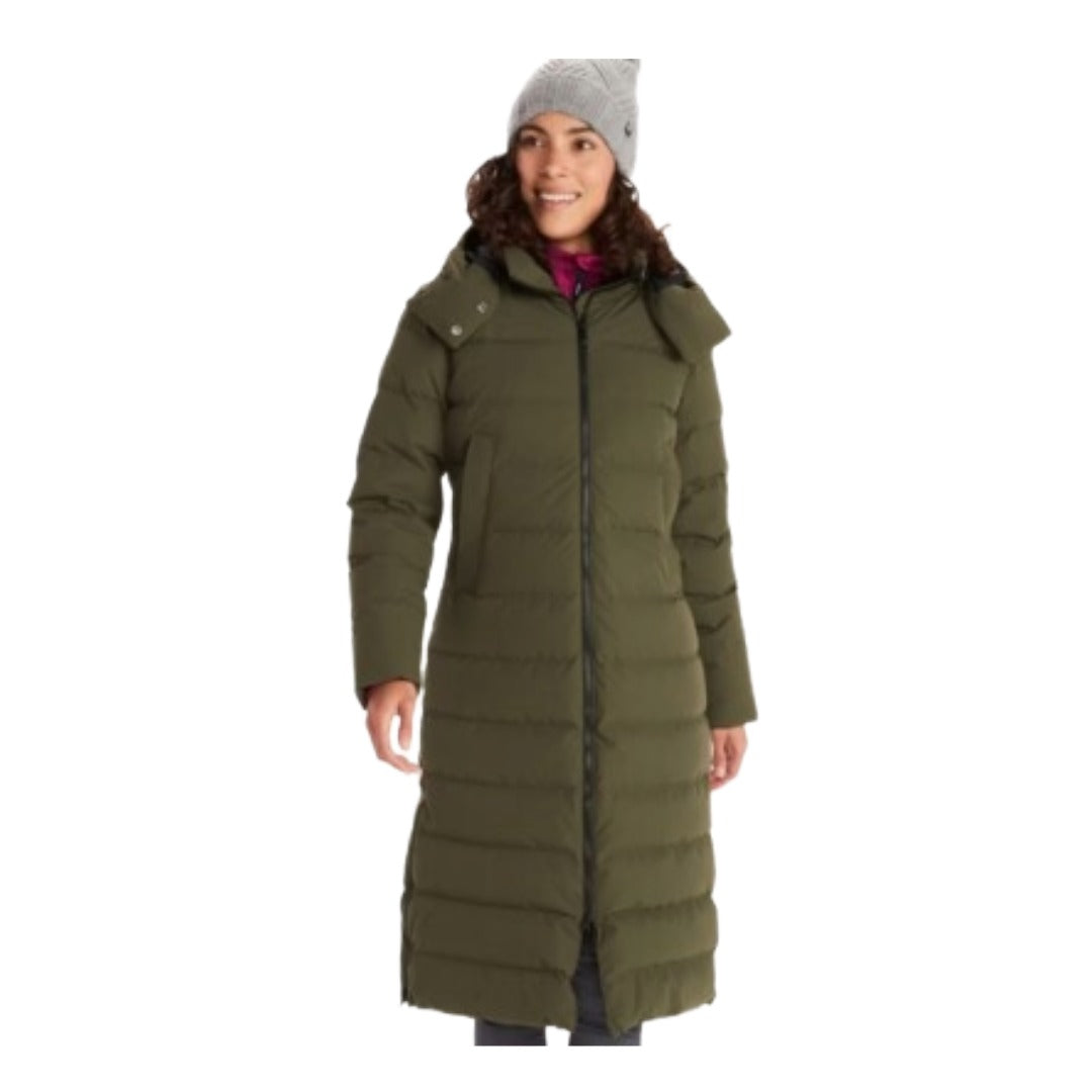 Woman wearing Marmot Prospect long down coat with hood, featuring a sleek full-length design, insulated construction, and waterproof fabric for winter protection