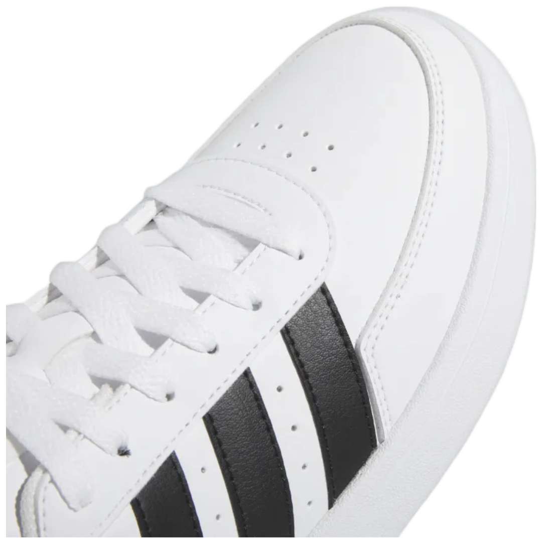 A pair of adidas Breaknet 2.0 sneakers for women in white with black strips. The sneakers feature a leather and synthetic upper, a rubber outsole, and the adidas logo on the side.