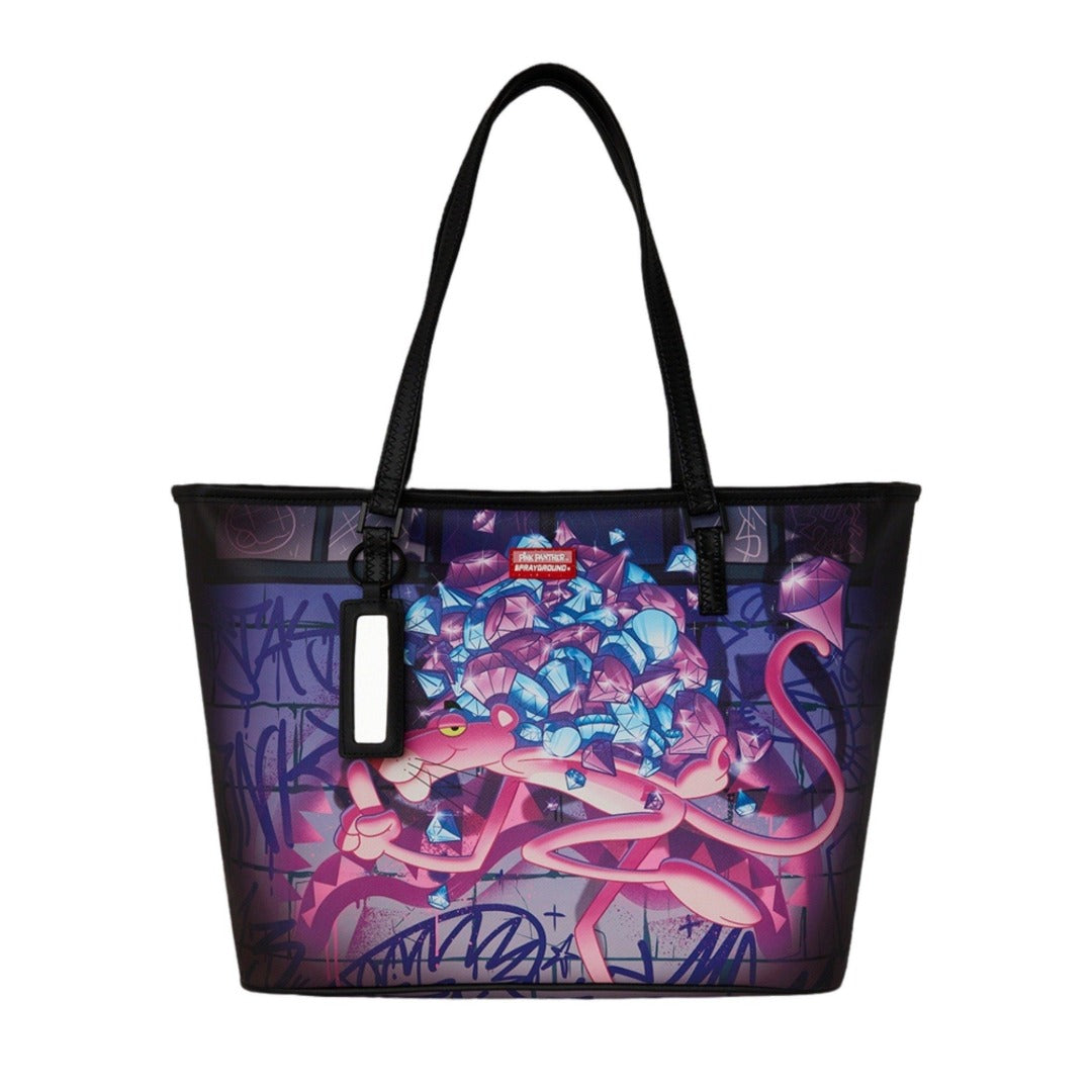 SPRAYGROUND Pink Panther Heist Tote Bag featuring bold Pink Panther artwork on pink vegan leather with SPRAYGROUND branding and dual carry handles.