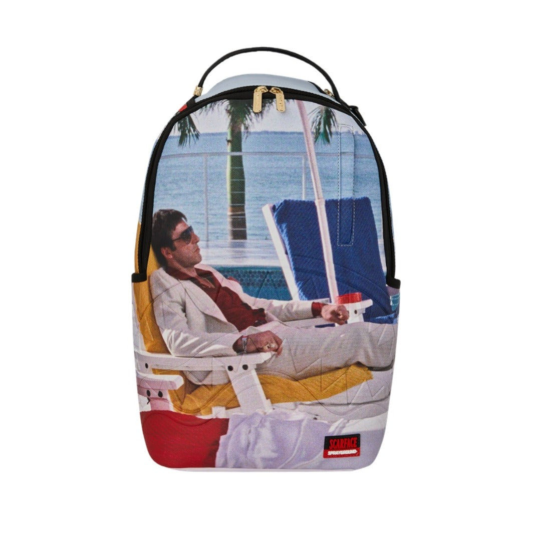 SPRAYGROUND Scarface Tony Montana Poolside DLXSV Backpack featuring vibrant Tony Montana graphic on black vegan leather with SPRAYGROUND logo detailing.