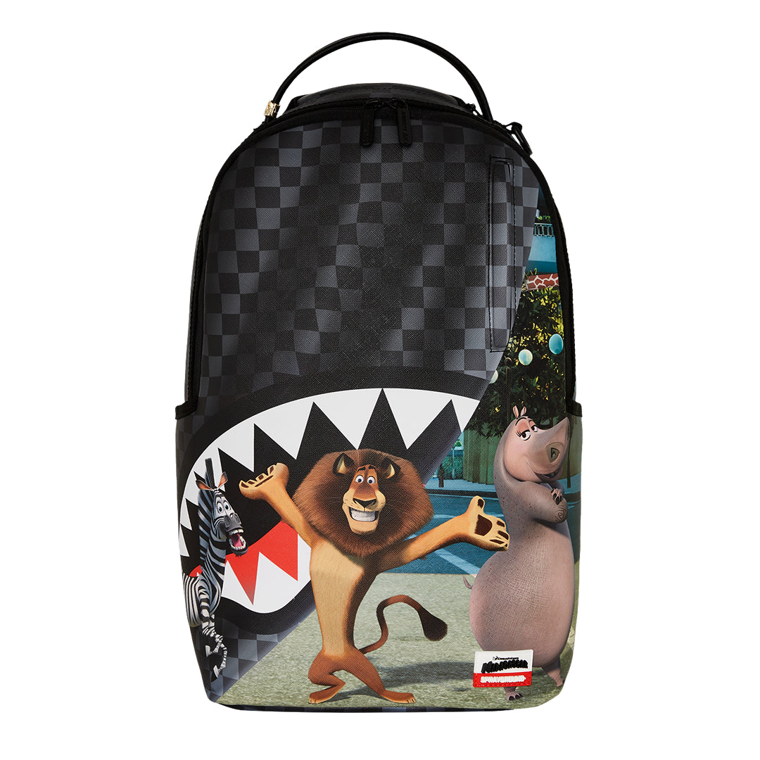 SPRAYGROUND Madagascar NYC Reveal DLXSV Backpack featuring Madagascar characters with curtain-reveal design and New York City backdrop on durable vegan leather







