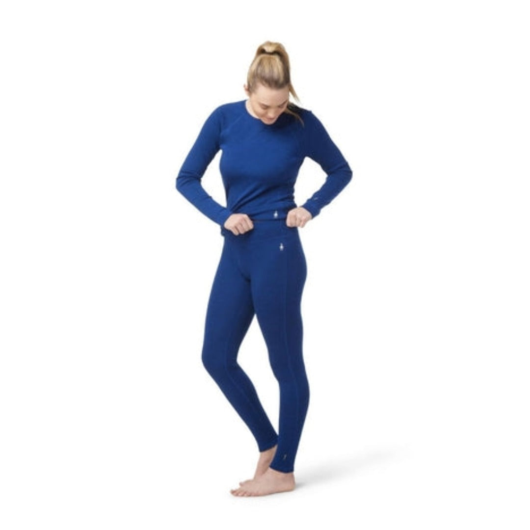 Women’s merino wool thermal base layer bottoms featuring breathable cold-weather comfort, flexible layering performance, and streamlined outdoor styling