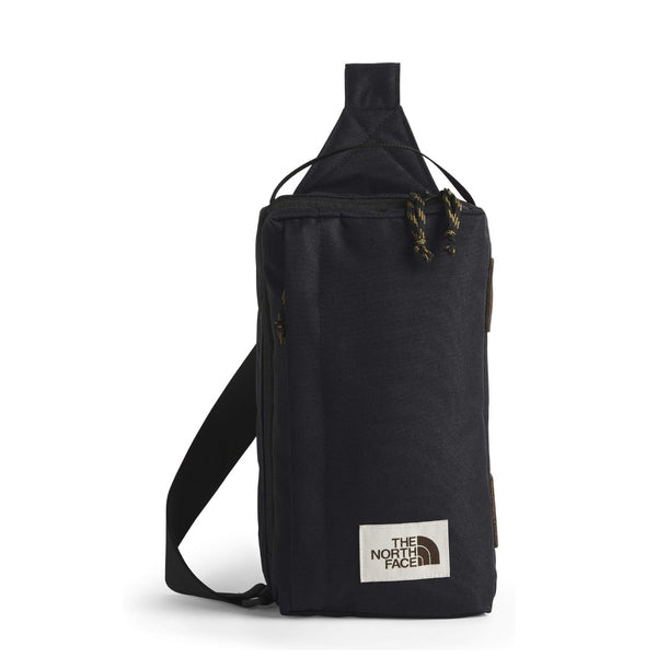 The North Face Berkeley Field Bag in beige with black strap and zippered compartments, styled as a compact crossbody bag.
