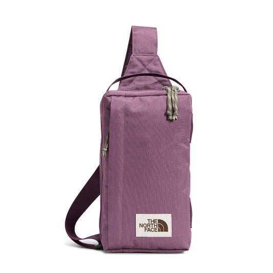 The North Face Berkeley Field Bag in beige with black strap and zippered compartments, styled as a compact crossbody bag.