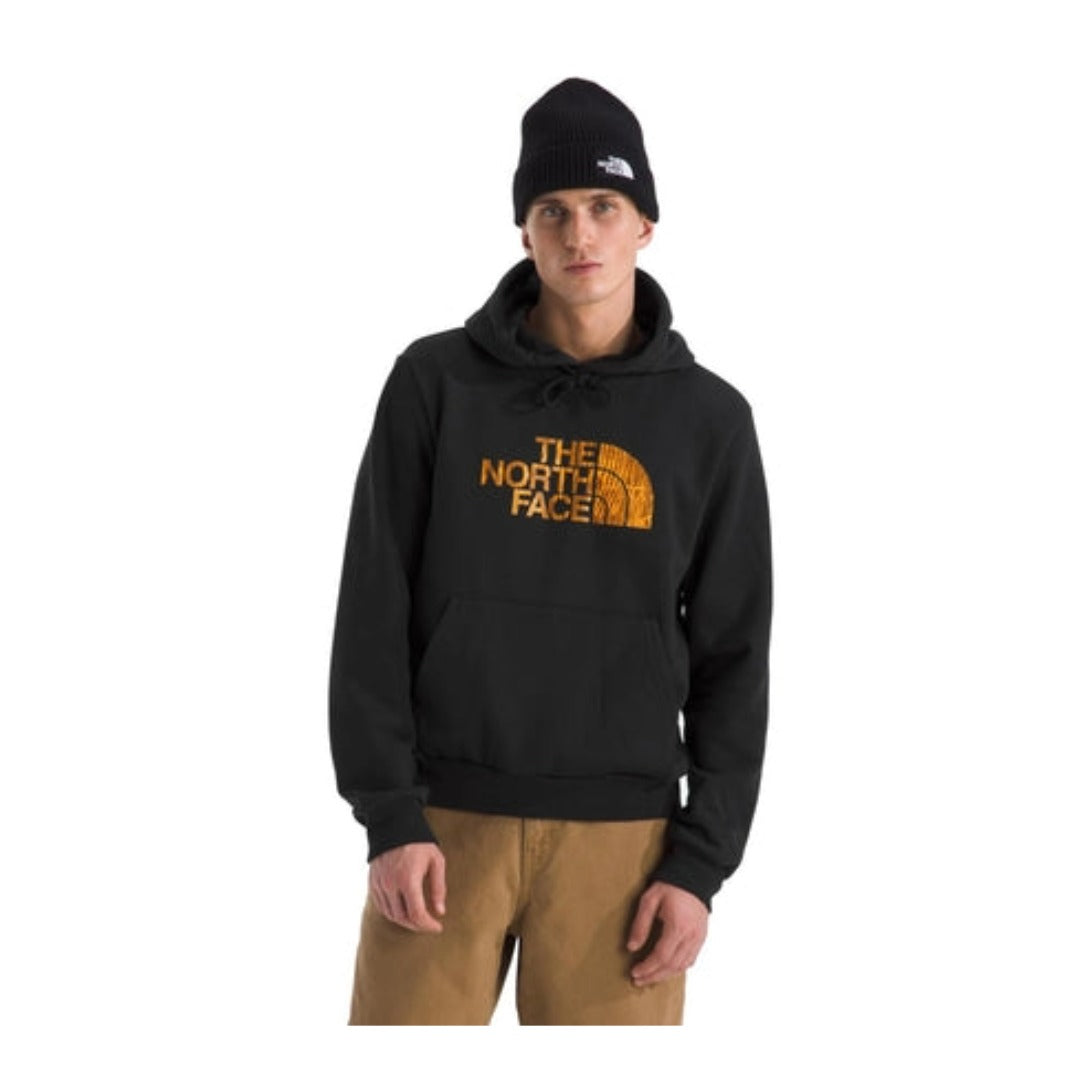 Man wearing a North Face hoodie with Half Dome logo, featuring a drawstring hood and kangaroo pocket in a casual setting.