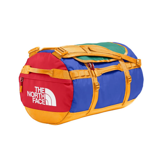 The North Face Base Camp Duffel - S in yellow and black, featuring padded handles, detachable shoulder straps, and a secure D-zip closure.