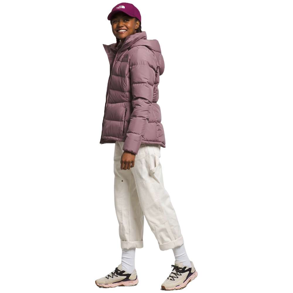 A stylish North Face Women's Metropolis Jacket in fawn grey worn by a woman against a snowy backdrop.