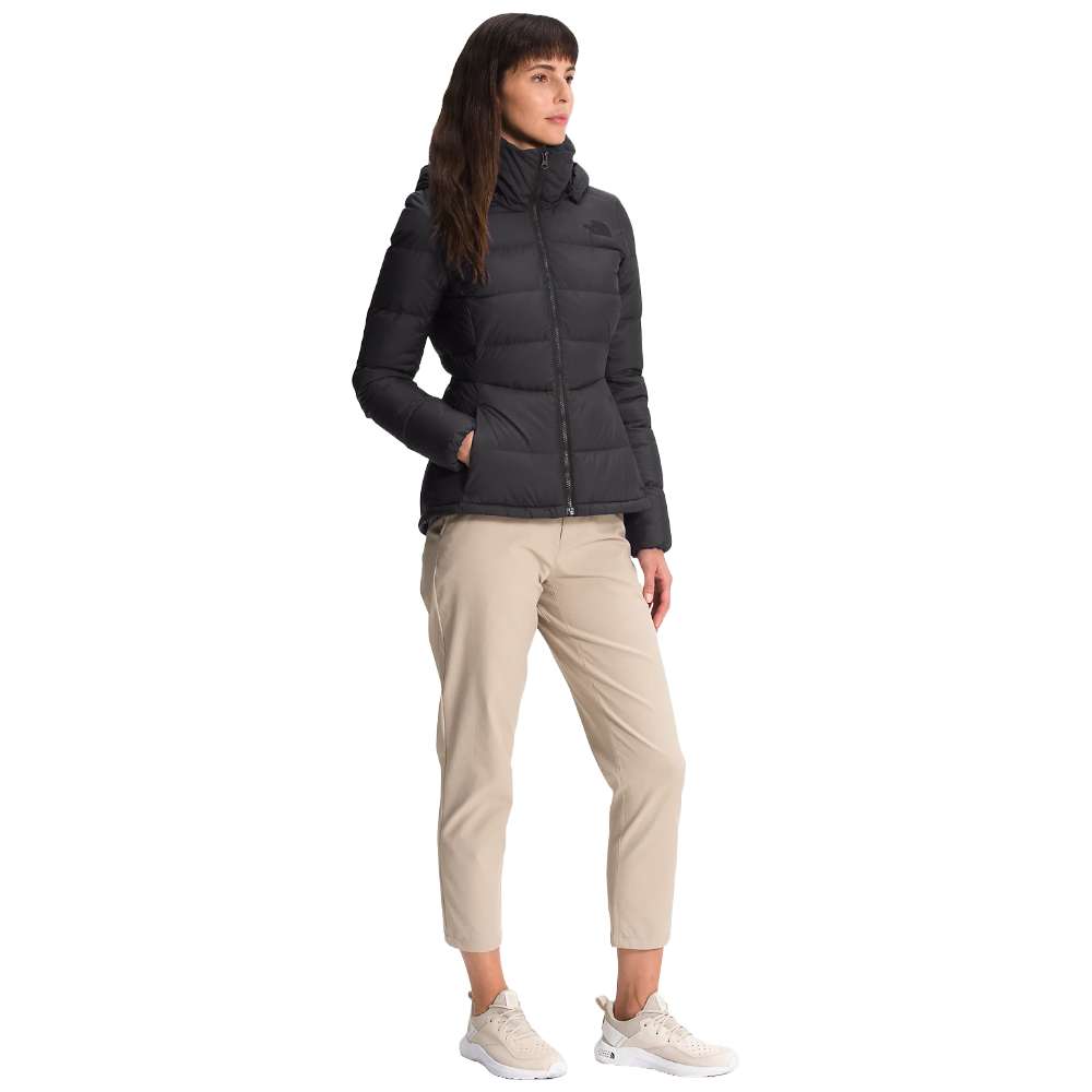 A stylish North Face Women's Metropolis Jacket in sleek black, worn by a woman against a snowy backdrop.