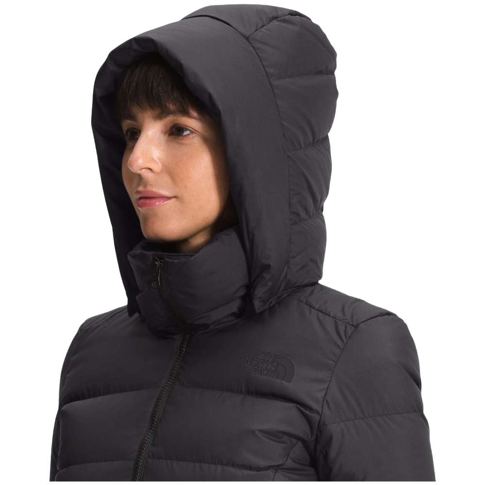 A stylish North Face Women's Metropolis Jacket in sleek black, worn by a woman against a snowy backdrop.