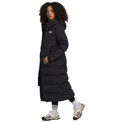 A sleek black north face women's triple c parka worn by women.