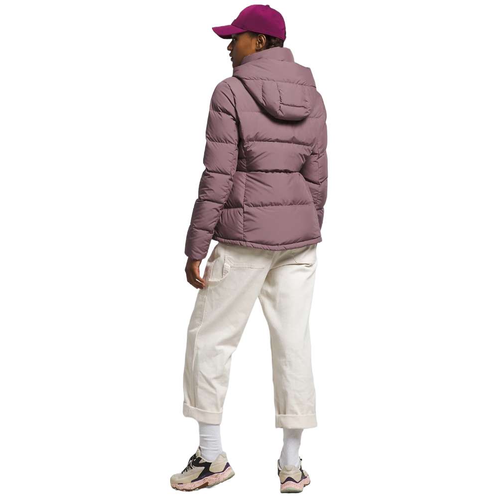 A stylish North Face Women's Metropolis Jacket in fawn grey worn by a woman against a snowy backdrop.