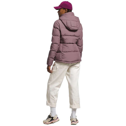 A stylish North Face Women's Metropolis Jacket in fawn grey worn by a woman against a snowy backdrop.