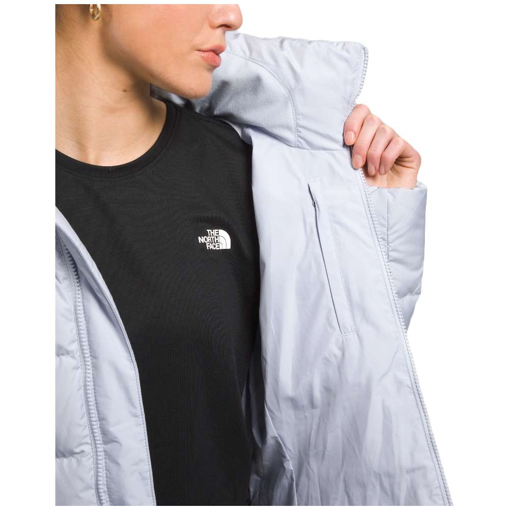 A stylish North Face Women's Metropolis Jacket in dusty periwinkle worn by a woman against a snowy backdrop.