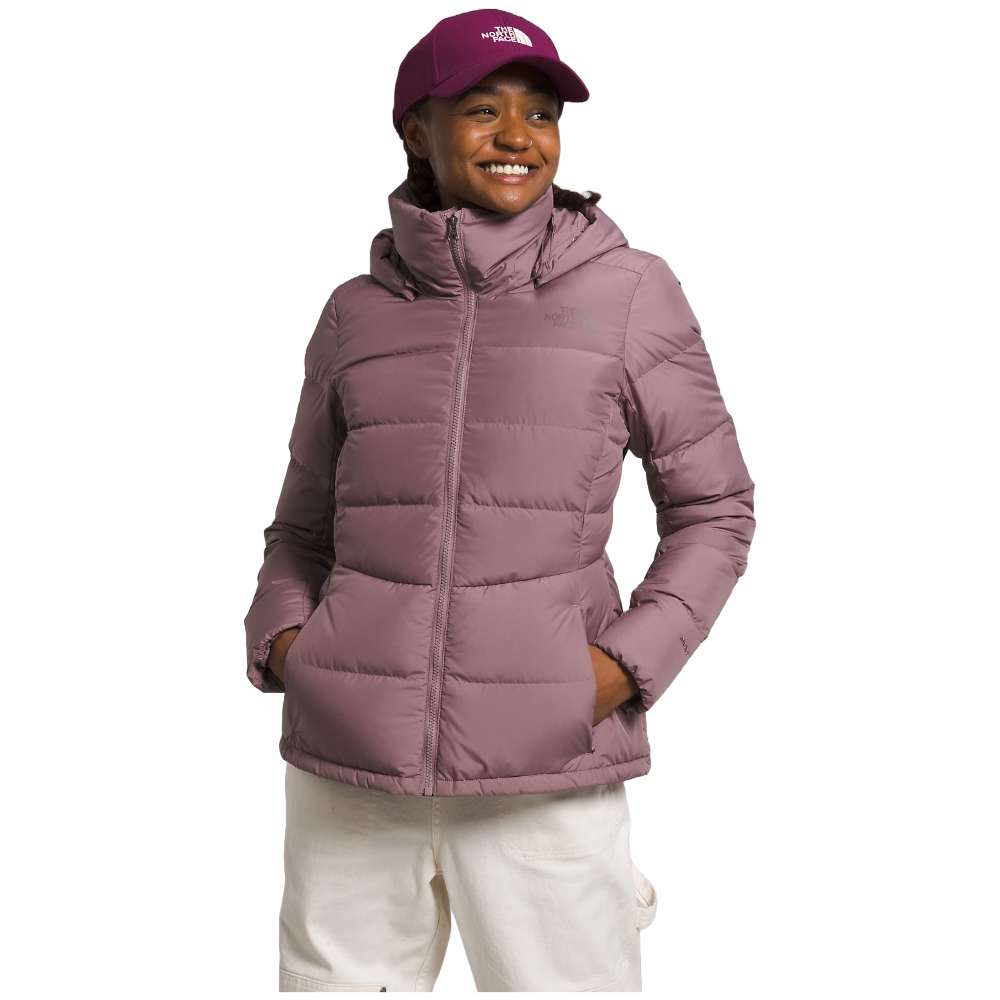 A stylish North Face Women's Metropolis Jacket in fawn grey worn by a woman against a snowy backdrop.