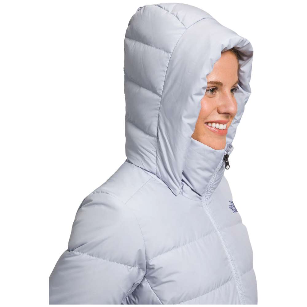 A stylish North Face Women's Metropolis Jacket in dusty periwinkle worn by a woman against a snowy backdrop.
