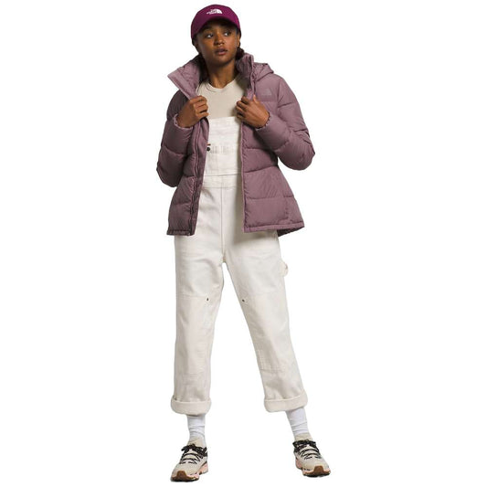 A stylish North Face Women's Metropolis Jacket in fawn grey worn by a woman against a snowy backdrop.