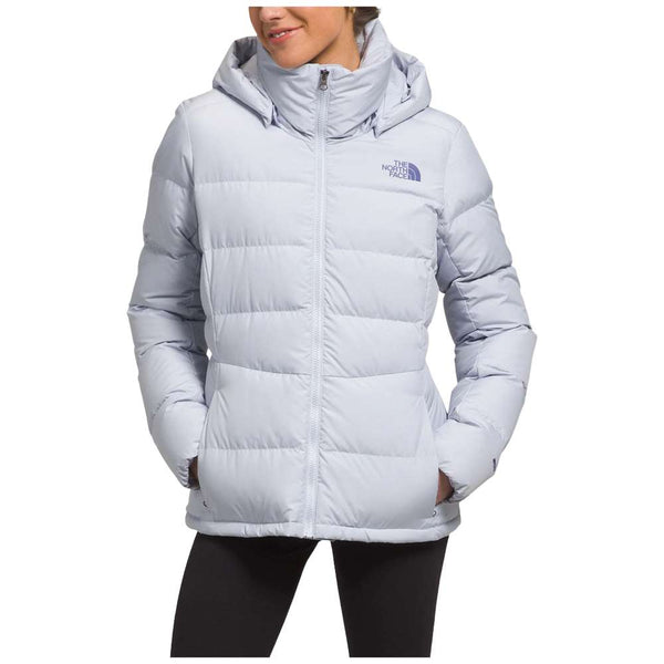 A stylish North Face Women's Metropolis Jacket in dusty periwinkle worn by a woman against a snowy backdrop.