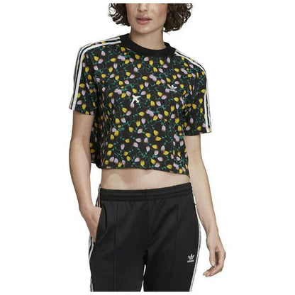 A cropped t-shirt featuring the adidas Originals logo in a vibrant all-over print, paired with high-waisted jeans. The logo creates a bold and dynamic pattern on the shirt