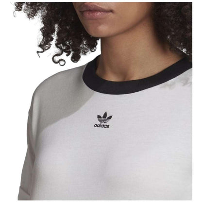 A close-up image of a woman wearing an adidas Originals Women's Cropped Top in a vibrant color, with the adidas logo prominently displayed.