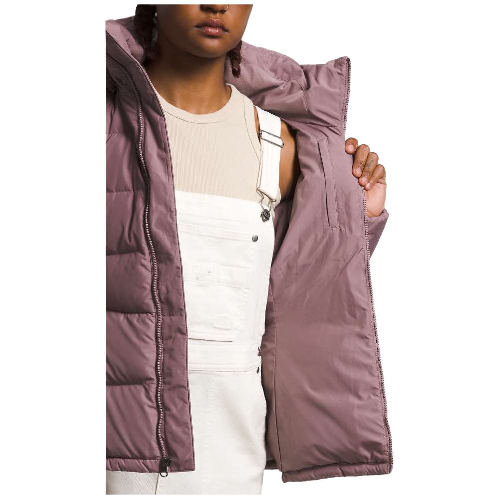 A stylish North Face Women's Metropolis Jacket in fawn grey worn by a woman against a snowy backdrop.