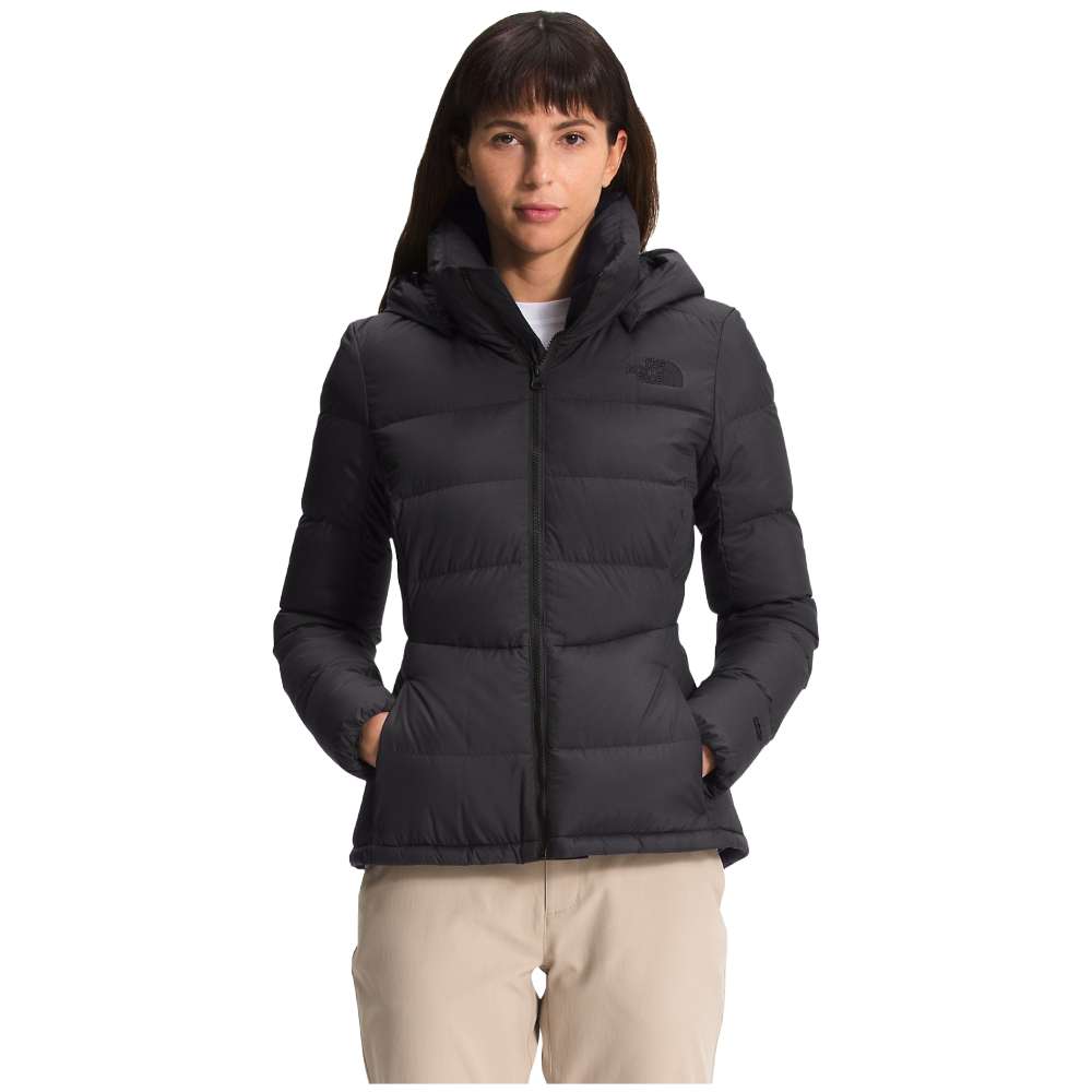A stylish North Face Women's Metropolis Jacket in sleek black, worn by a woman against a snowy backdrop.