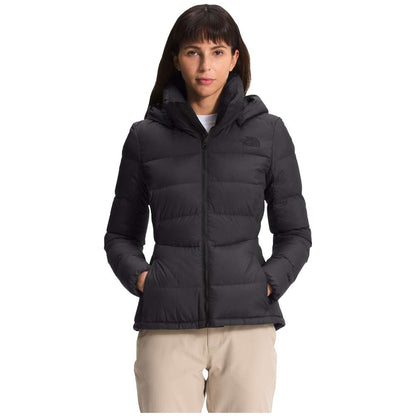 A stylish North Face Women's Metropolis Jacket in sleek black, worn by a woman against a snowy backdrop.
